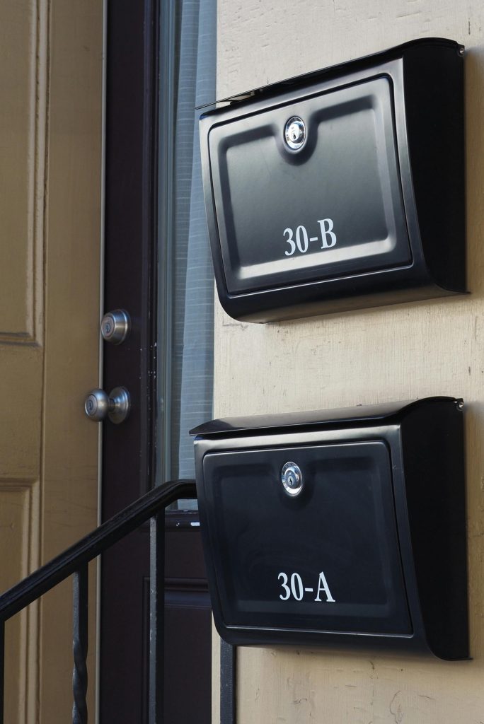 Two black mailboxes labeled 30-A and 30-B on a yellow-painted building in Doylestown, Pennsylvania.